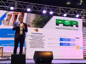 A foto mostra uma pessoa discursando, apresentando o projeto PDR