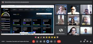 A imagem mostra várias pessoas em uma reunião virtual acompanhando uma apresentação